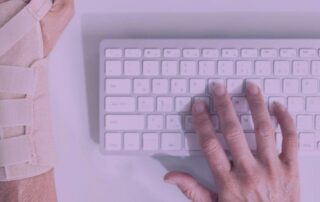 Computer user with sprained left hand typing with right hand